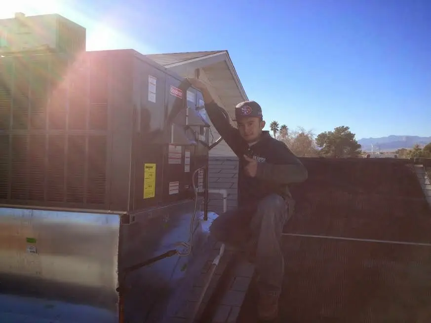 HVAC technician performing AC Tune-Up on a rooftop unit in North Auburn